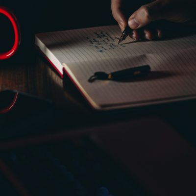 Hand writing in a notebook in low light