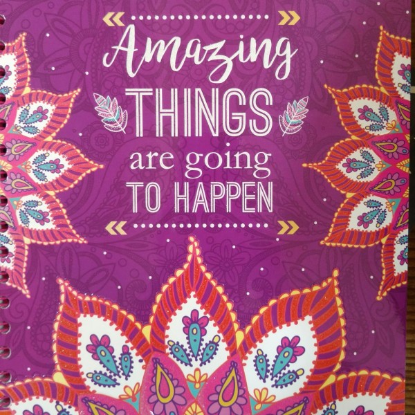 Colorful cover of a spiral notebook with the phrase "Amazing things are going to happen"