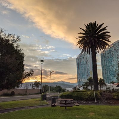 Sunrise view of a park, hills, and buildings